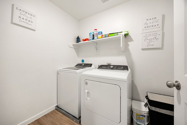 clothes washing area featuring hardwood / wood-style flooring and separate washer and dryer