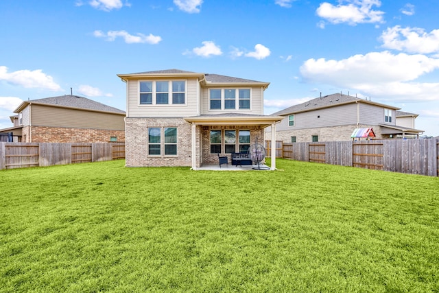 rear view of house featuring a yard and a patio