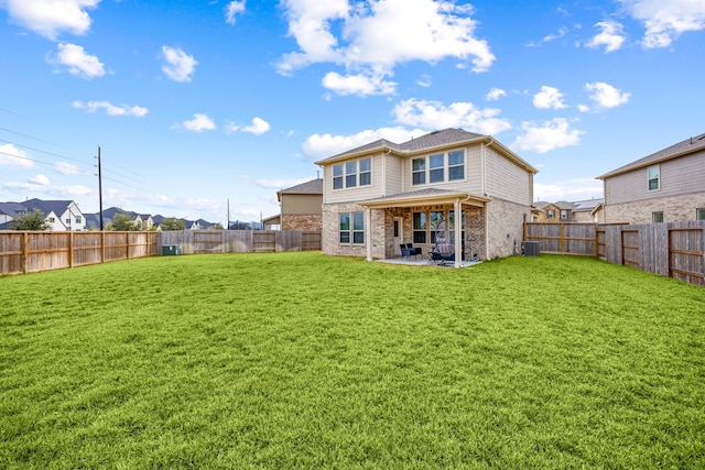 back of property featuring cooling unit, a yard, and a patio