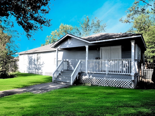 view of front of property with a porch, a front lawn, and a shingled roof