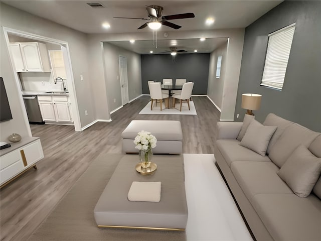 living room with sink, hardwood / wood-style flooring, and ceiling fan