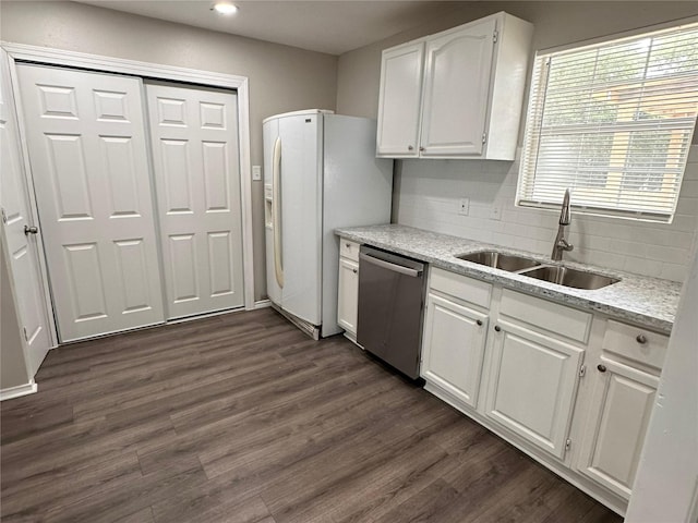 kitchen with dishwasher, sink, white cabinets, dark hardwood / wood-style flooring, and decorative backsplash