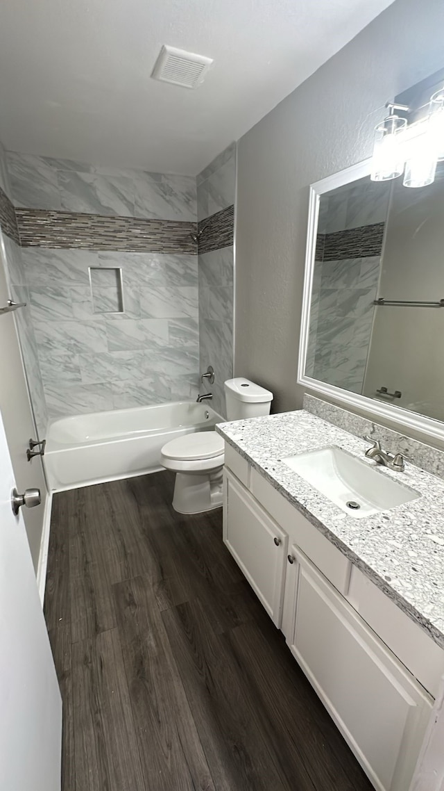 full bathroom featuring vanity, toilet, wood finished floors, and bathing tub / shower combination