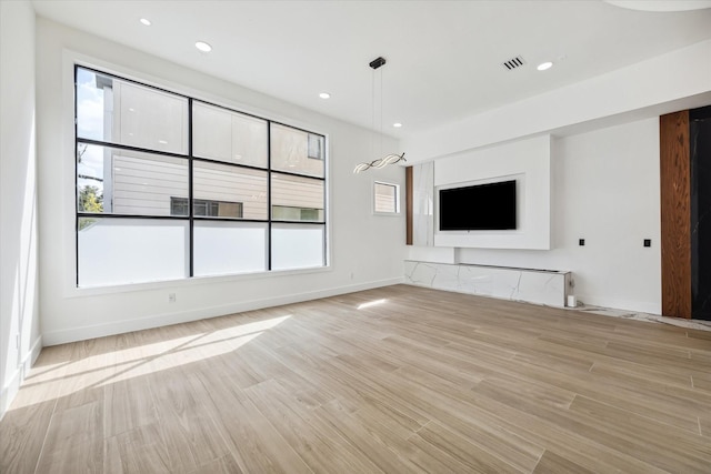 unfurnished living room featuring a healthy amount of sunlight and light wood-type flooring