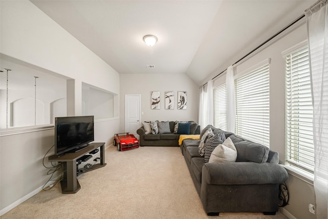 carpeted living area with visible vents, baseboards, and lofted ceiling