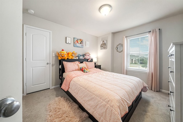 bedroom with light colored carpet and baseboards