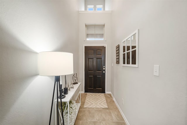 foyer with baseboards and a high ceiling