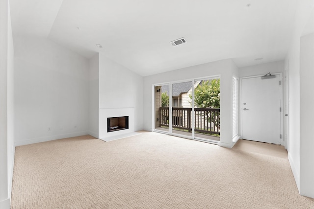 2829 Timmons Ln Unit 202, Houston, TX 77027 - unfurnished living room featuring lofted ceiling, carpet flooring, a fireplace with flush hearth, and baseboards