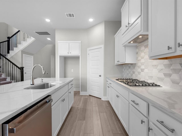 29651 Bur Creek Ln, Fulshear, TX 77441 - kitchen with a sink, stainless steel appliances, light stone countertops, white cabinetry, and recessed lighting