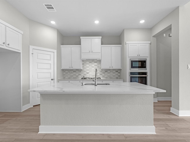 29651 Bur Creek Ln, Fulshear, TX 77441 - kitchen featuring oven, a sink, built in microwave, light wood finished floors, and recessed lighting