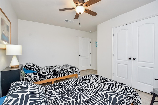 bedroom featuring ceiling fan, light hardwood / wood-style floors, and a closet