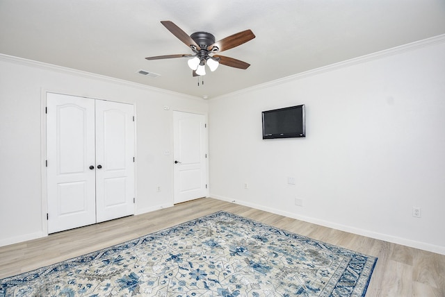 bedroom with ceiling fan, ornamental molding, light hardwood / wood-style floors, and a closet