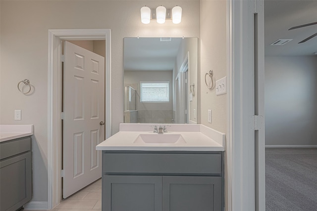 bathroom with walk in shower, ceiling fan, vanity, and tile patterned floors