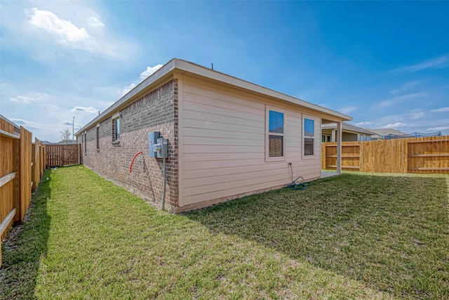 view of side of home with a yard