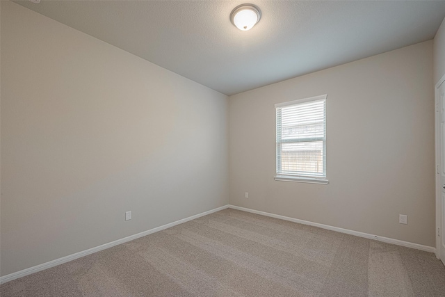 spare room featuring light carpet