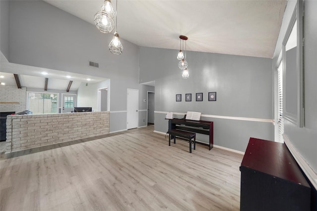 living room with high vaulted ceiling, light hardwood / wood-style floors, and beamed ceiling