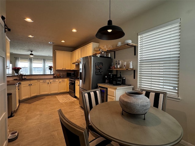 kitchen with sink, ceiling fan, appliances with stainless steel finishes, white cabinetry, and decorative light fixtures