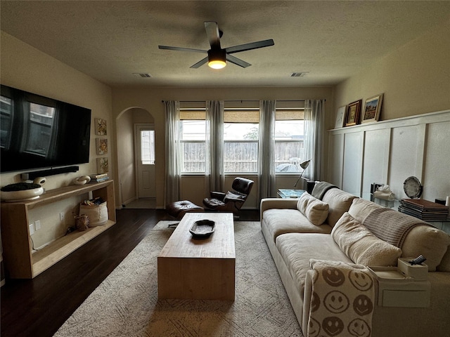 living room with ceiling fan, dark hardwood / wood-style flooring, and a textured ceiling