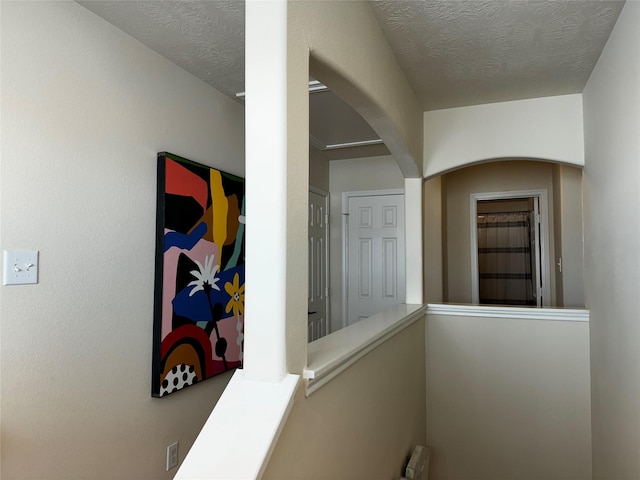 corridor with radiator heating unit and a textured ceiling