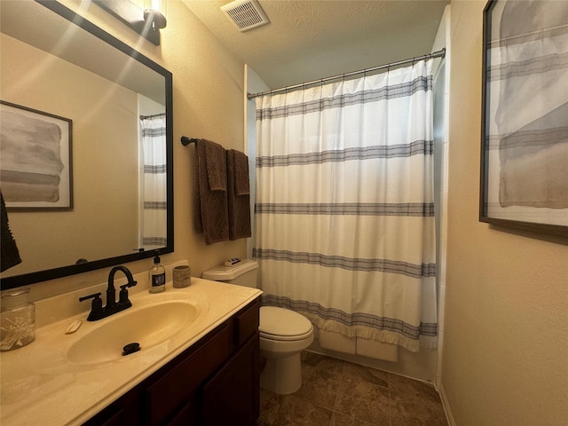 full bathroom featuring vanity, shower / tub combo with curtain, a textured ceiling, and toilet