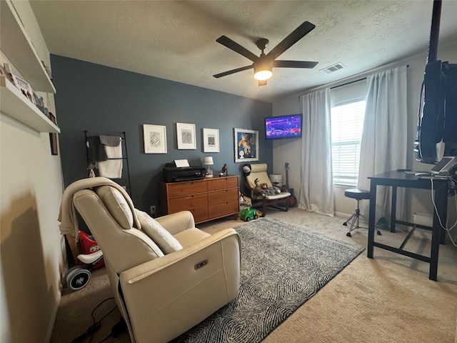 interior space with a textured ceiling, ceiling fan, and carpet flooring