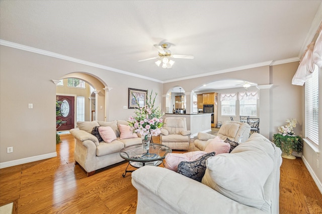 living room featuring decorative columns, ceiling fan, and light hardwood / wood-style flooring