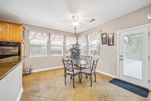 tiled dining room featuring ceiling fan