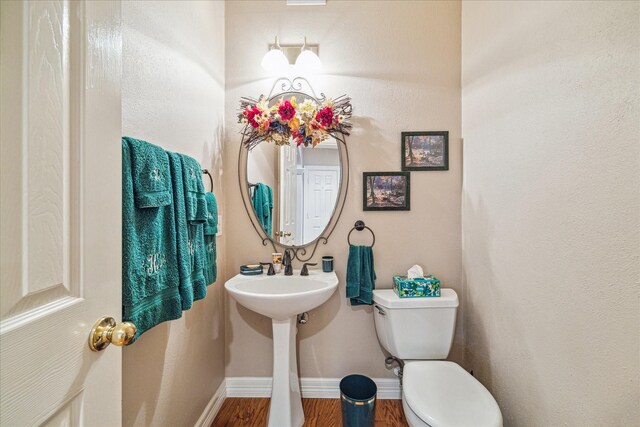 bathroom featuring wood-type flooring and toilet