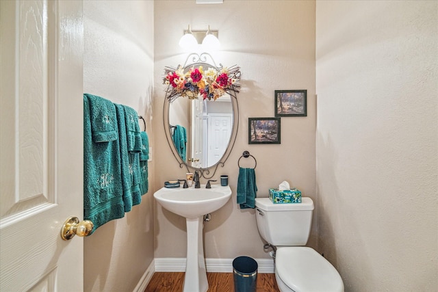 bathroom featuring wood-type flooring and toilet