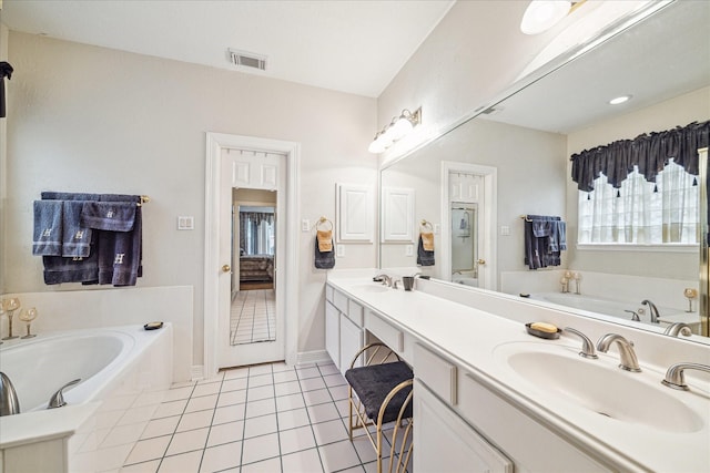 bathroom with vanity, tile patterned flooring, and a bathtub