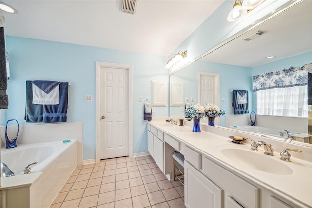 bathroom with tile patterned flooring, a bathing tub, and vanity