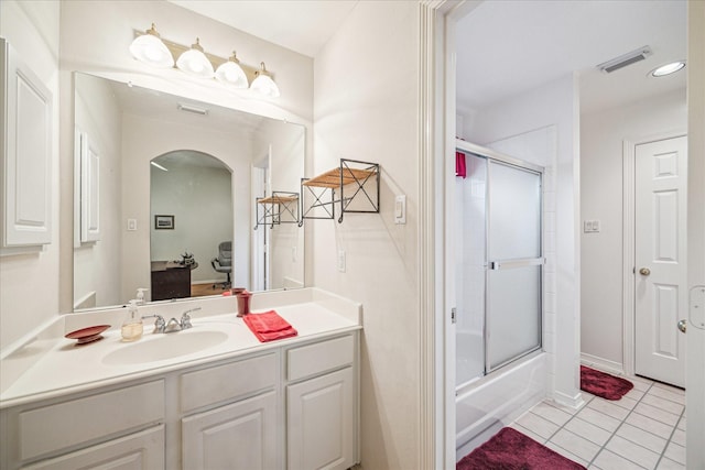 bathroom featuring vanity, combined bath / shower with glass door, and tile patterned floors