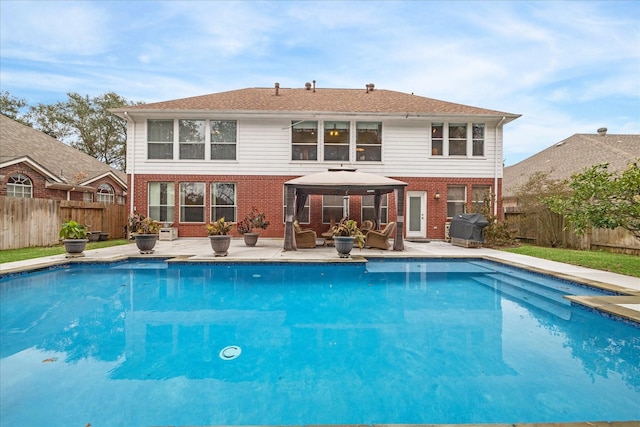 rear view of property featuring a patio area, an outdoor living space, a fenced in pool, and a gazebo