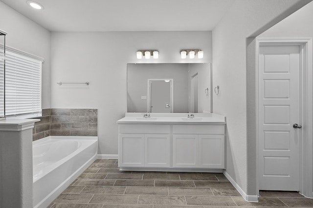 bathroom featuring vanity and a bath