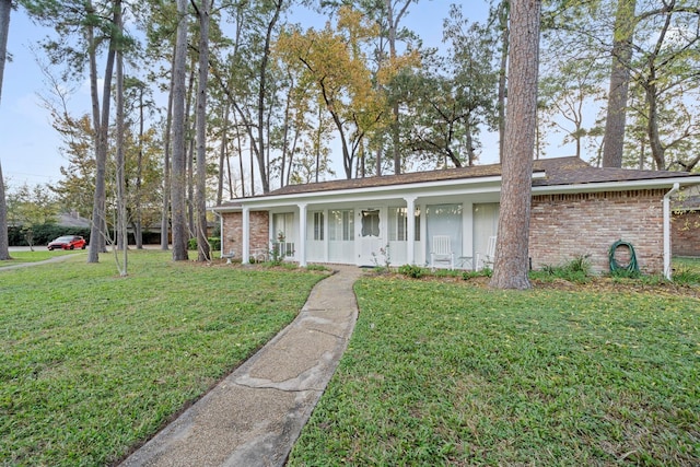 ranch-style house with a front yard and a porch