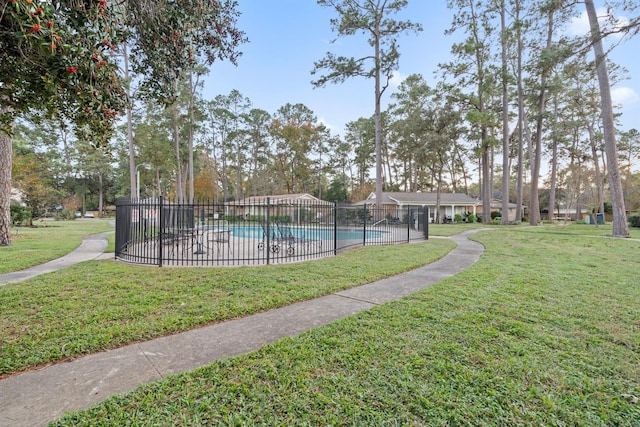 view of pool with a lawn