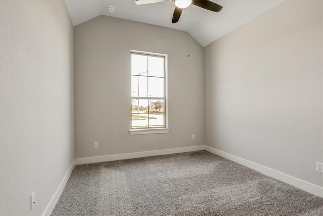 carpeted empty room featuring baseboards, ceiling fan, and vaulted ceiling