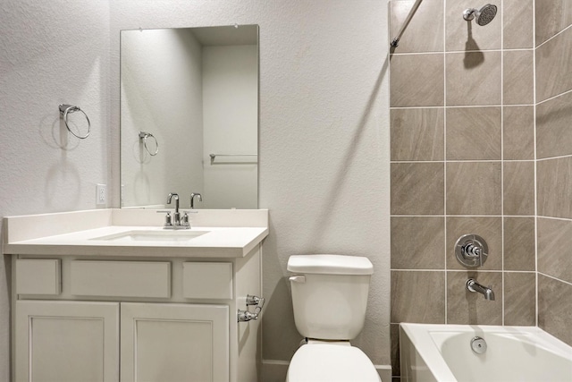 bathroom with vanity, toilet, tub / shower combination, and a textured wall