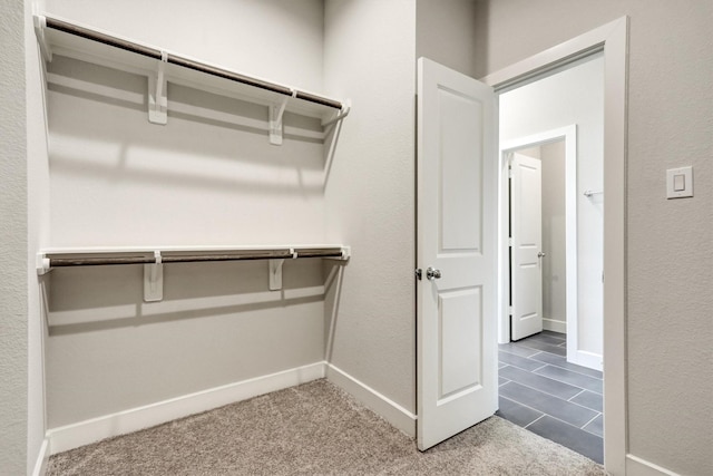 spacious closet featuring dark carpet