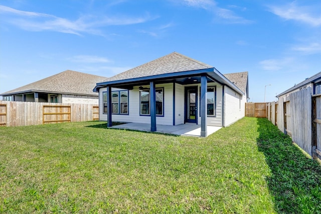 rear view of house featuring a patio, a yard, a fenced backyard, and roof with shingles