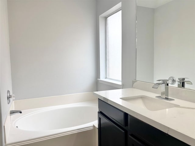 bathroom featuring vanity and a bath