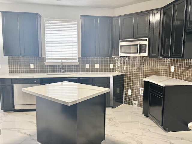 kitchen with tasteful backsplash, sink, a kitchen island, and appliances with stainless steel finishes