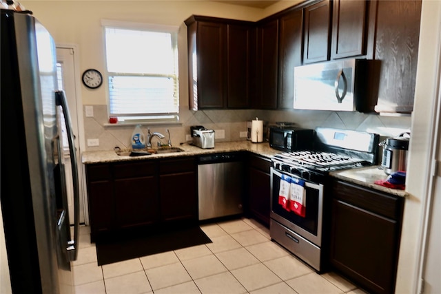 kitchen with sink, backsplash, dark brown cabinets, and stainless steel appliances