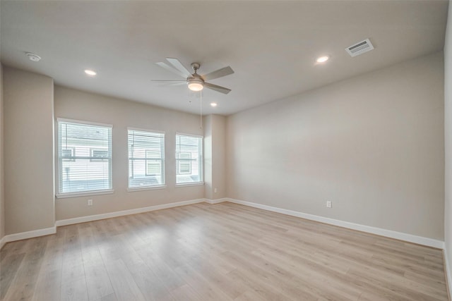 empty room featuring light wood-type flooring, baseboards, and recessed lighting