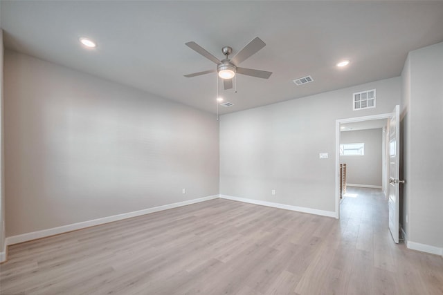 unfurnished room featuring light wood-type flooring, baseboards, and visible vents