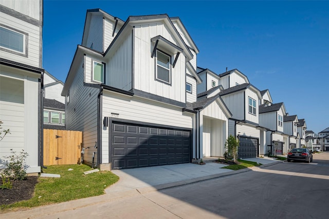 view of front facade featuring concrete driveway, board and batten siding, an attached garage, and a residential view