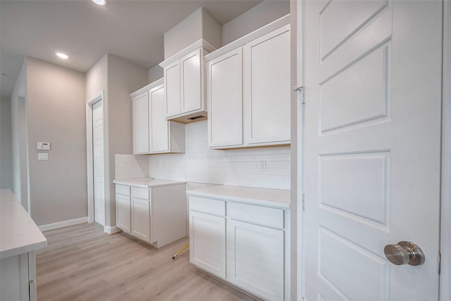 kitchen with light wood-style floors, recessed lighting, light countertops, and decorative backsplash