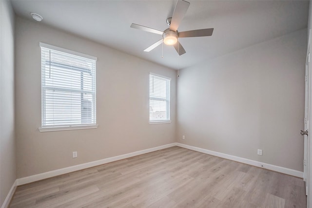 spare room with a ceiling fan, light wood-style flooring, and baseboards