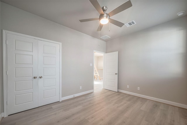 unfurnished bedroom featuring a closet, baseboards, visible vents, and light wood finished floors