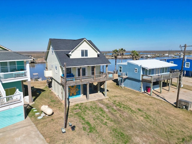 rear view of house with a patio and a water view